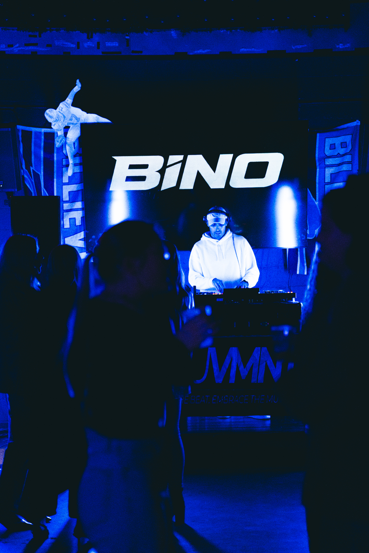 Crowd raising hands at a BiNO performance with BINO on the LED screen
